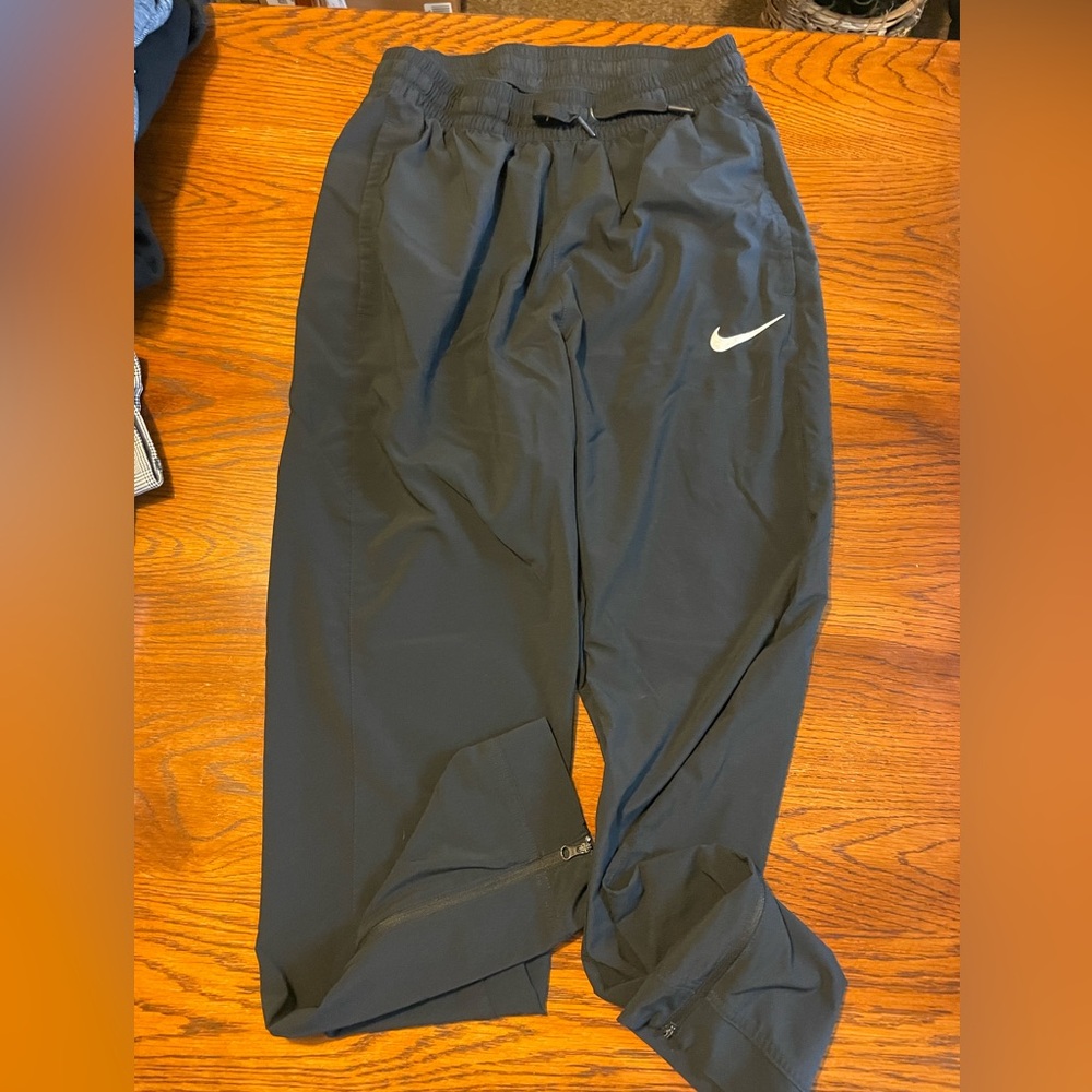 NIKE- men’s black Dri Fit joggers with pockets and ankle zip closure.